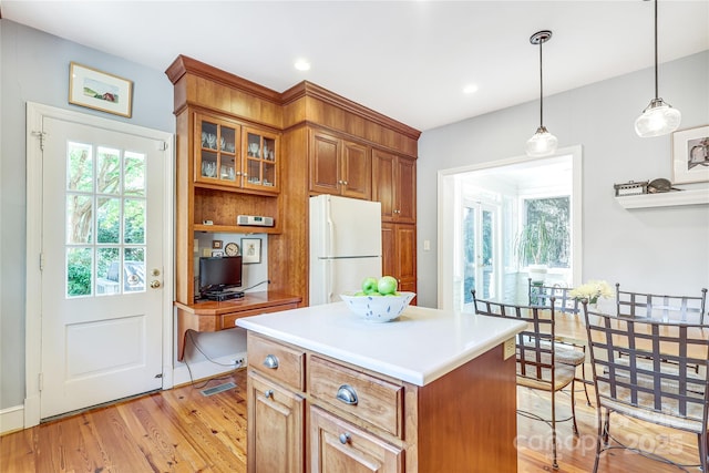 1021 Isleworth Ave, Charlotte, NC 28203 - kitchen featuring freestanding refrigerator, plenty of natural light, brown cabinets, light wood-style floors, and recessed lighting
