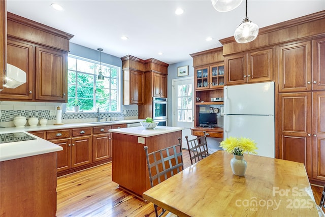 1021 Isleworth Ave, Charlotte, NC 28203 - kitchen featuring freestanding refrigerator, light wood-style flooring, light countertops, tasteful backsplash, and recessed lighting