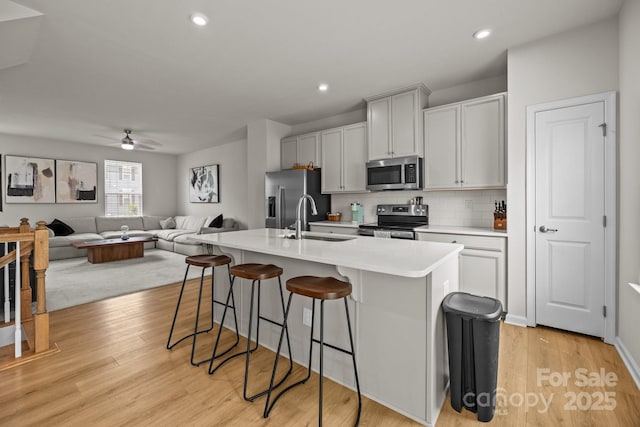 3108 Beeler Ln, Charlotte, NC 28208 - kitchen featuring stainless steel appliances, a sink, a kitchen breakfast bar, an island with sink, and ceiling fan