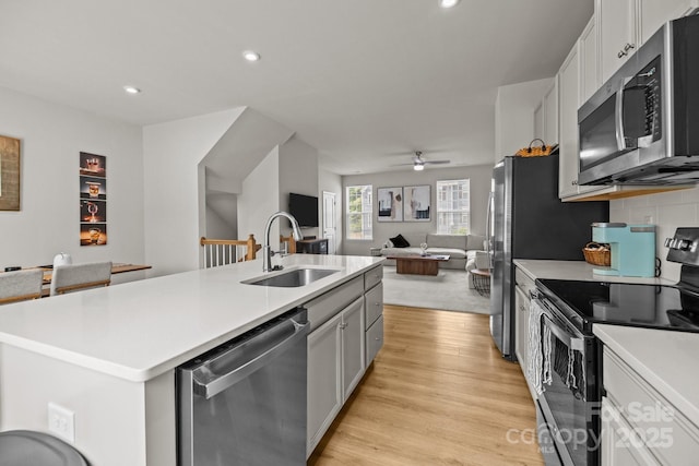 3108 Beeler Ln, Charlotte, NC 28208 - kitchen featuring stainless steel appliances, a sink, open floor plan, light countertops, and light wood-style flooring