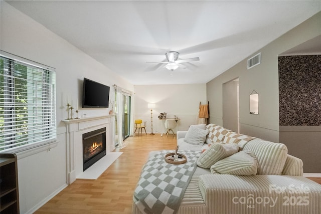 3737 Winding Creek Ln, Charlotte, NC 28226 - living room with ceiling fan, light wood-style flooring, a glass covered fireplace, and baseboards