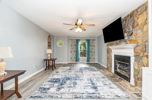 3884 Snider Cir, Hickory, NC 28602 - living room with a fireplace, arched walkways, ceiling fan, and wood finished floors