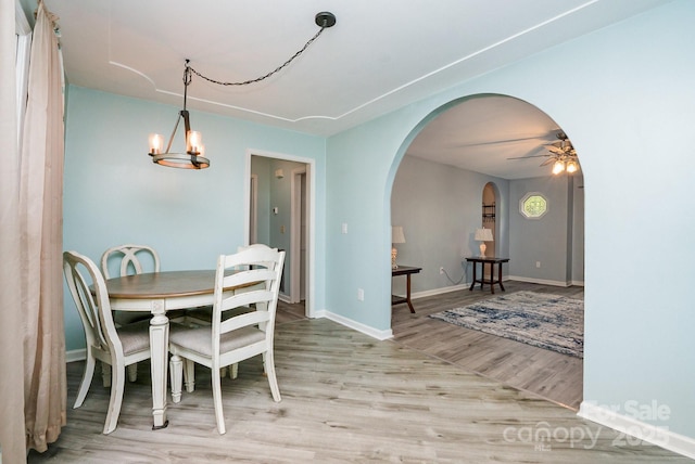3884 Snider Cir, Hickory, NC 28602 - dining area with arched walkways, light wood finished floors, a ceiling fan, and baseboards