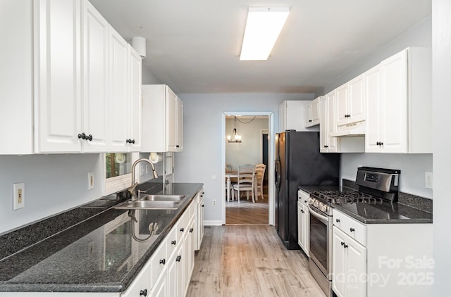 3884 Snider Cir, Hickory, NC 28602 - kitchen with stainless steel gas stove, a sink, under cabinet range hood, white cabinetry, and light wood finished floors