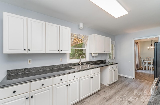 3884 Snider Cir, Hickory, NC 28602 - kitchen featuring a sink, white cabinets, a chandelier, dark countertops, and light wood-style floors