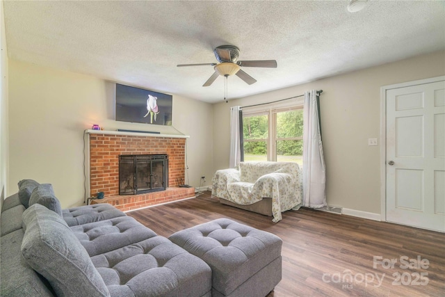 166 Stephanie Dr, Lexington, NC 27295 - living room featuring a ceiling fan, wood finished floors, a textured ceiling, a brick fireplace, and baseboards