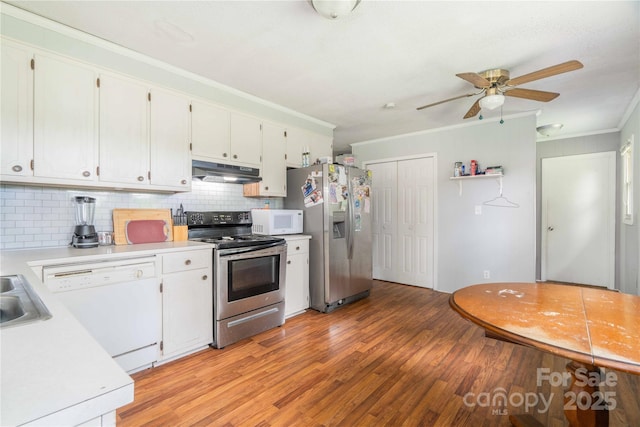 166 Stephanie Dr, Lexington, NC 27295 - kitchen with appliances with stainless steel finishes, under cabinet range hood, ornamental molding, light wood-style flooring, and backsplash