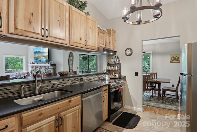 44 Falls Creek Rd, Pisgah Forest, NC 28768 - kitchen with appliances with stainless steel finishes, a chandelier, dark countertops, light brown cabinets, and vaulted ceiling