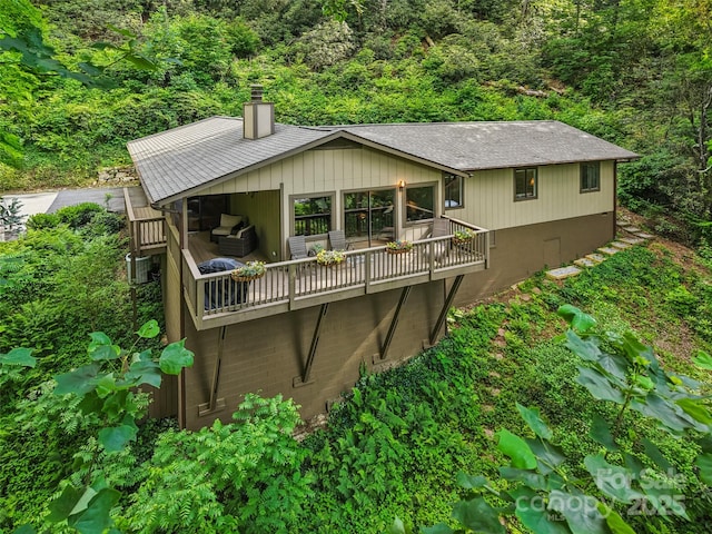 44 Falls Creek Rd, Pisgah Forest, NC 28768 - rear view of property featuring a chimney, a view of trees, a deck, and an outdoor hangout area