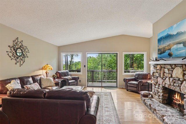 44 Falls Creek Rd, Pisgah Forest, NC 28768 - living area featuring lofted ceiling, wood finished floors, a fireplace, and a textured ceiling