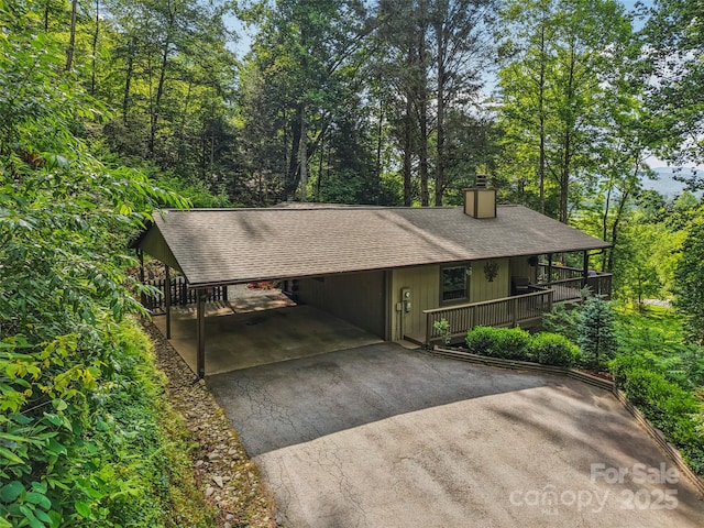 44 Falls Creek Rd, Pisgah Forest, NC 28768 - view of front facade with asphalt driveway, a chimney, a shingled roof, and an attached carport