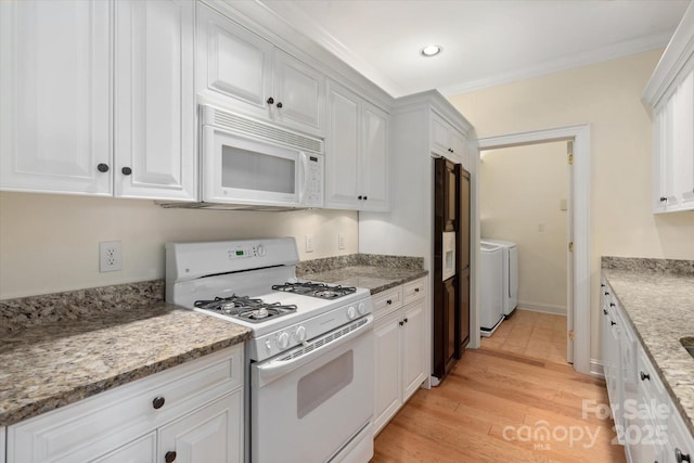 5601 Fairview Rd Unit 11, Charlotte, NC 28209 - kitchen featuring white appliances, washer and dryer, white cabinetry, light wood-type flooring, and recessed lighting
