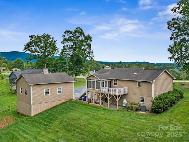 321 Jupiter Rd, Weaverville, NC 28787 - back of house with a sunroom, a deck with mountain view, a lawn, cooling unit, and a chimney