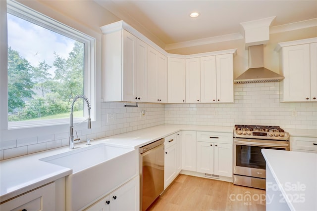 1062 Willow Ridge Ln, Fort Mill, SC 29707 - kitchen featuring stainless steel appliances, a sink, wall chimney exhaust hood, light countertops, and ornamental molding