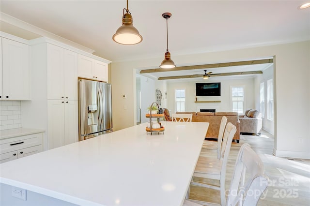 1062 Willow Ridge Ln, Fort Mill, SC 29707 - kitchen featuring stainless steel fridge with ice dispenser, a kitchen island, a fireplace, white cabinets, and light countertops