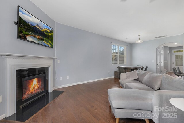 3230 Yarmouth Ln, Gastonia, NC 28056 - living room with arched walkways, wood finished floors, a glass covered fireplace, and baseboards