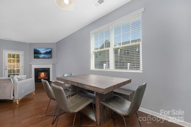 3230 Yarmouth Ln, Gastonia, NC 28056 - dining room featuring a glass covered fireplace, dark wood-style flooring, and baseboards
