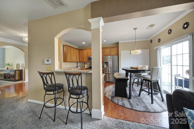 920 Old Forester Ln, Charlotte, NC 28214 - kitchen with stainless steel appliances, a breakfast bar area, carpet floors, baseboards, and arched walkways