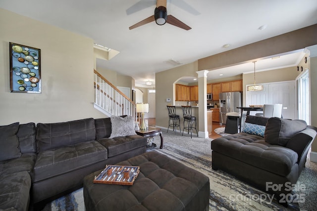920 Old Forester Ln, Charlotte, NC 28214 - carpeted living area featuring a ceiling fan, stairs, ornate columns, and arched walkways