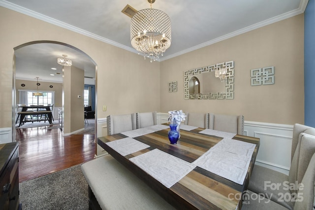 920 Old Forester Ln, Charlotte, NC 28214 - dining room featuring arched walkways, a chandelier, crown molding, wood finished floors, and baseboards