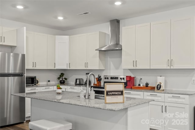 2813 Ava Ave, Charlotte, NC 28208 - kitchen with appliances with stainless steel finishes, wall chimney exhaust hood, white cabinetry, a center island with sink, and recessed lighting