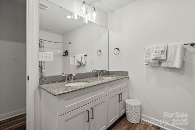 2813 Ava Ave, Charlotte, NC 28208 - full bath with wood finished floors, double vanity, curtained shower, and baseboards