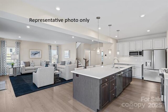1817 Ab Moore Jr Dr Unit 3240, Indian Trail, NC 28079 - kitchen featuring stainless steel appliances, a sink, white cabinetry, wood finished floors, and recessed lighting