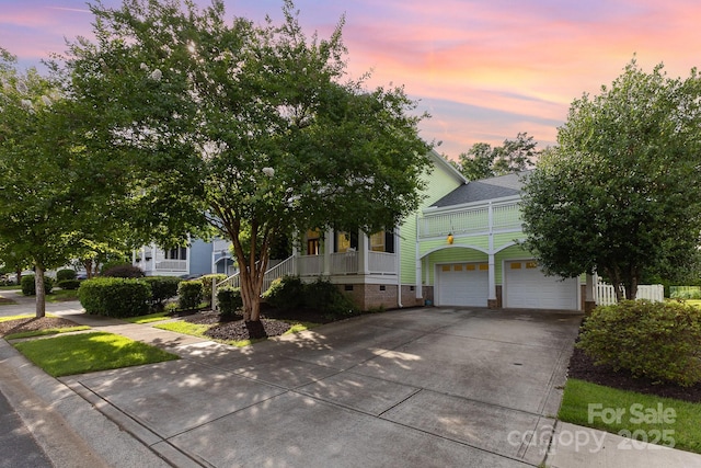 9210 Ginhouse Ln, Charlotte, NC 28277 - view of property hidden behind natural elements featuring concrete driveway, crawl space, an attached garage, covered porch, and a shingled roof