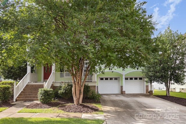 9210 Ginhouse Ln, Charlotte, NC 28277 - view of property hidden behind natural elements featuring concrete driveway, a garage, covered porch, stairs, and brick siding
