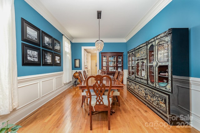 9210 Ginhouse Ln, Charlotte, NC 28277 - dining room featuring a chandelier, ornamental molding, wood finished floors, and a wainscoted wall