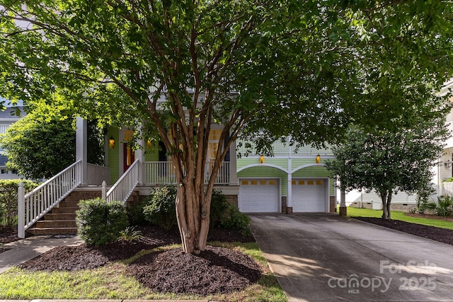 9210 Ginhouse Ln, Charlotte, NC 28277 - view of property hidden behind natural elements featuring driveway, covered porch, an attached garage, and stairway