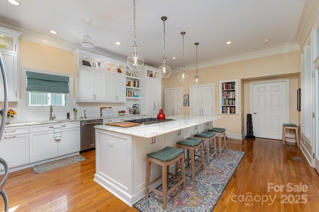 9210 Ginhouse Ln, Charlotte, NC 28277 - kitchen with appliances with stainless steel finishes, ornamental molding, white cabinetry, a kitchen island, and a kitchen breakfast bar