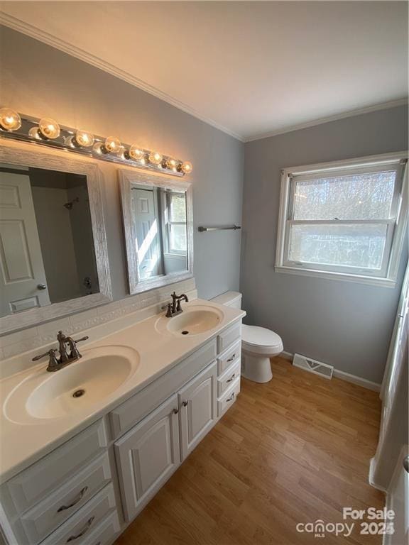 2405 Forrestbrook Dr, Kannapolis, NC 28083 - full bathroom featuring crown molding, double vanity, toilet, wood finished floors, and baseboards
