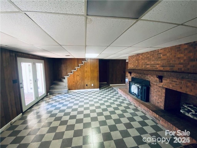 2405 Forrestbrook Dr, Kannapolis, NC 28083 - unfurnished living room featuring a paneled ceiling, wooden walls, stairway, baseboards, and tile patterned floors