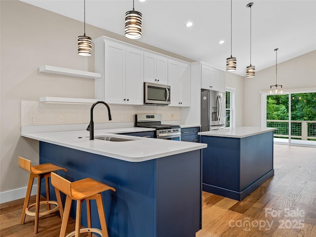 108 Le-An-Hurst Rd, Asheville, NC 28803 - kitchen featuring appliances with stainless steel finishes, backsplash, light wood finished floors, a kitchen island, and light countertops