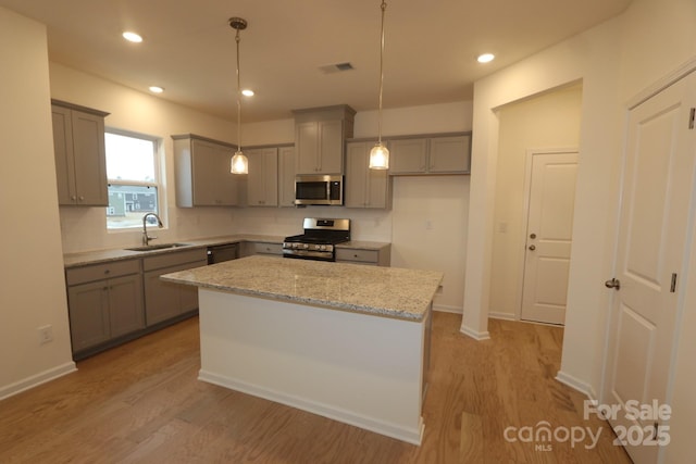 222 Harpers Run Ln, Matthews, NC 28104 - kitchen with stainless steel appliances, a sink, gray cabinets, light wood-style floors, and recessed lighting
