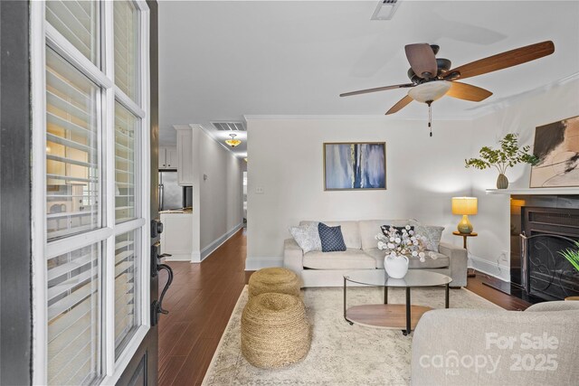 2813 Hilliard Dr, Charlotte, NC 28205 - living area featuring ornamental molding, wood finished floors, a fireplace with raised hearth, and ceiling fan