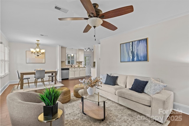 2813 Hilliard Dr, Charlotte, NC 28205 - living area featuring a chandelier, wood finished floors, a ceiling fan, and crown molding