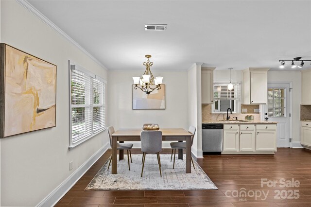 2813 Hilliard Dr, Charlotte, NC 28205 - dining area featuring a chandelier, healthy amount of natural light, dark wood-style floors, and ornamental molding