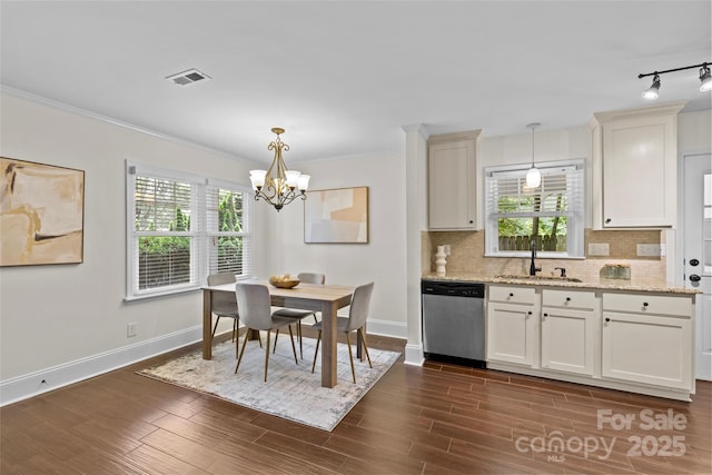 2813 Hilliard Dr, Charlotte, NC 28205 - dining space with a chandelier, crown molding, rail lighting, plenty of natural light, and dark wood-style floors