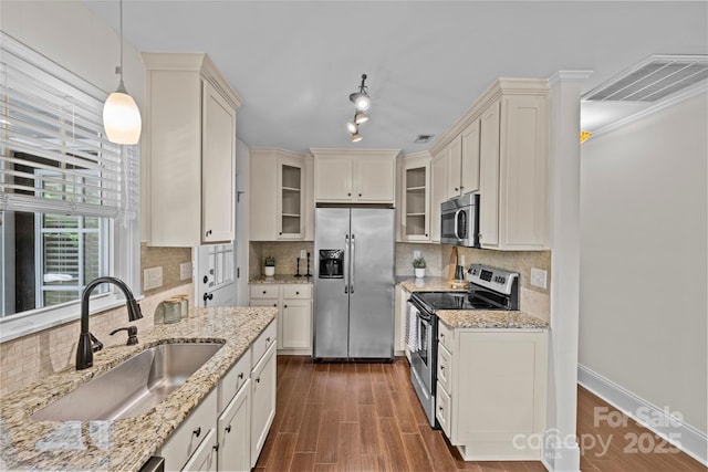 2813 Hilliard Dr, Charlotte, NC 28205 - kitchen with appliances with stainless steel finishes, glass insert cabinets, dark wood-style floors, decorative backsplash, and ornamental molding