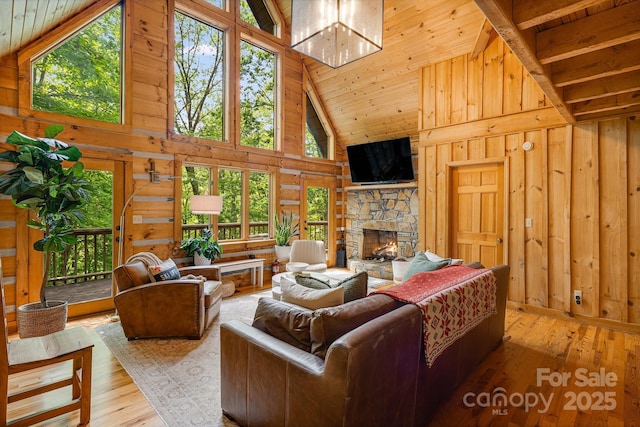 2255 Wolf Laurel Rd, Mars Hill, NC 28754 - living area with high vaulted ceiling, wooden walls, a stone fireplace, hardwood / wood-style floors, and wood ceiling