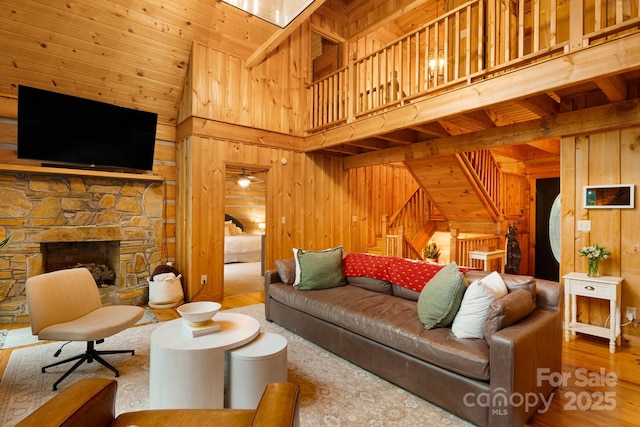 2255 Wolf Laurel Rd, Mars Hill, NC 28754 - living room with wooden walls, a high ceiling, wood finished floors, stairway, and a fireplace