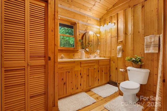 2255 Wolf Laurel Rd, Mars Hill, NC 28754 - bathroom featuring toilet, vaulted ceiling, vanity, wood finished floors, and wood walls
