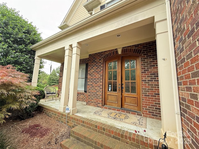 8620 Rolling Fields Rd, Charlotte, NC 28227 - view of exterior entry featuring covered porch, french doors, and brick siding