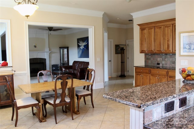8620 Rolling Fields Rd, Charlotte, NC 28227 - dining room with a ceiling fan, light tile patterned floors, ornamental molding, and a tiled fireplace
