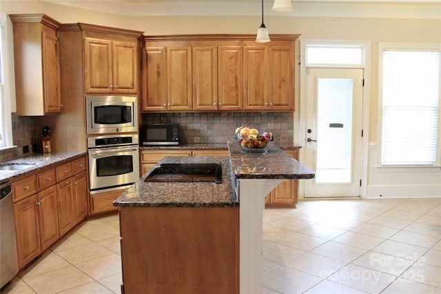 8620 Rolling Fields Rd, Charlotte, NC 28227 - kitchen with stainless steel appliances, a kitchen island, light tile patterned floors, ornamental molding, and dark stone counters