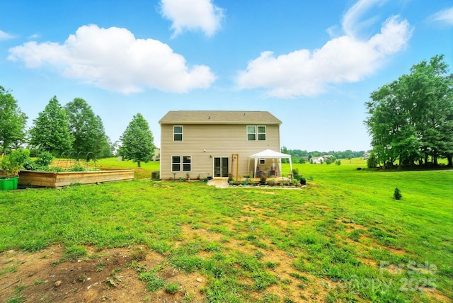 124 Vintage Woods Ct, Shelby, NC 28150 - rear view of house with a vegetable garden, a lawn, and a patio area