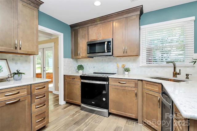 1011 Bydeford Ct, Matthews, NC 28105 - kitchen featuring stainless steel appliances, a sink, light wood finished floors, and backsplash
