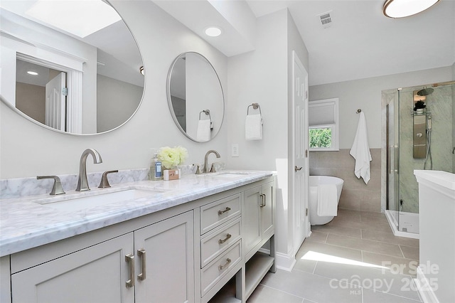 1011 Bydeford Ct, Matthews, NC 28105 - bathroom featuring tile patterned floors, double vanity, a stall shower, a freestanding bath, and tile walls